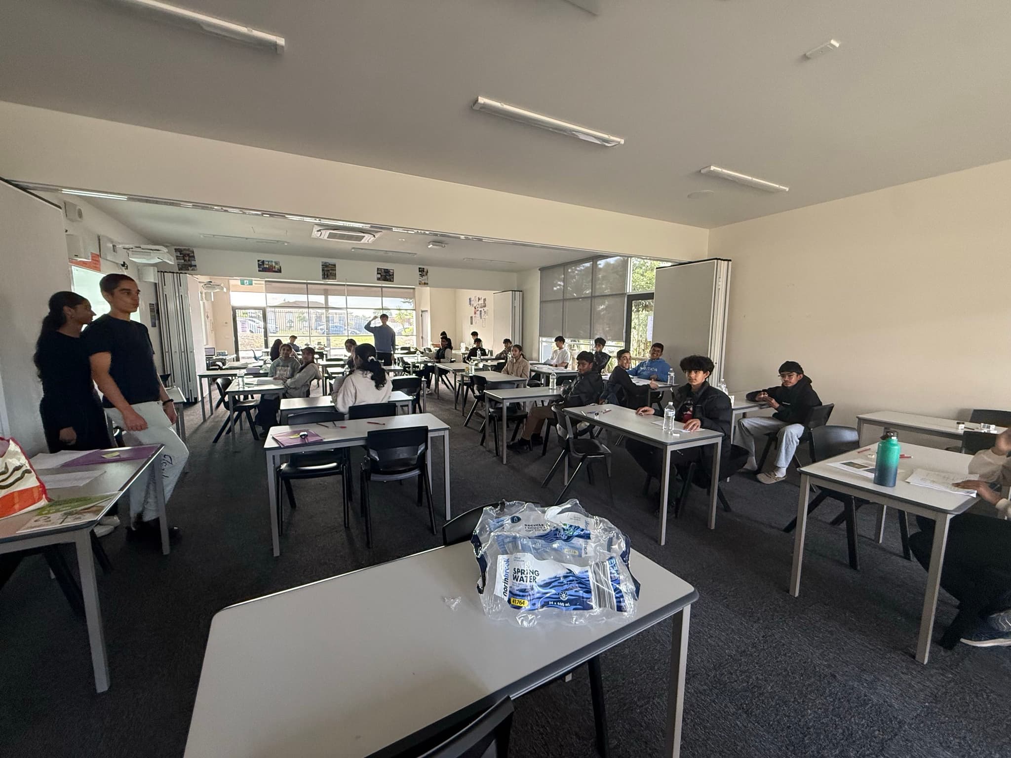 An in-person session in progress, the tutor standing at the front of a room of seated students.
