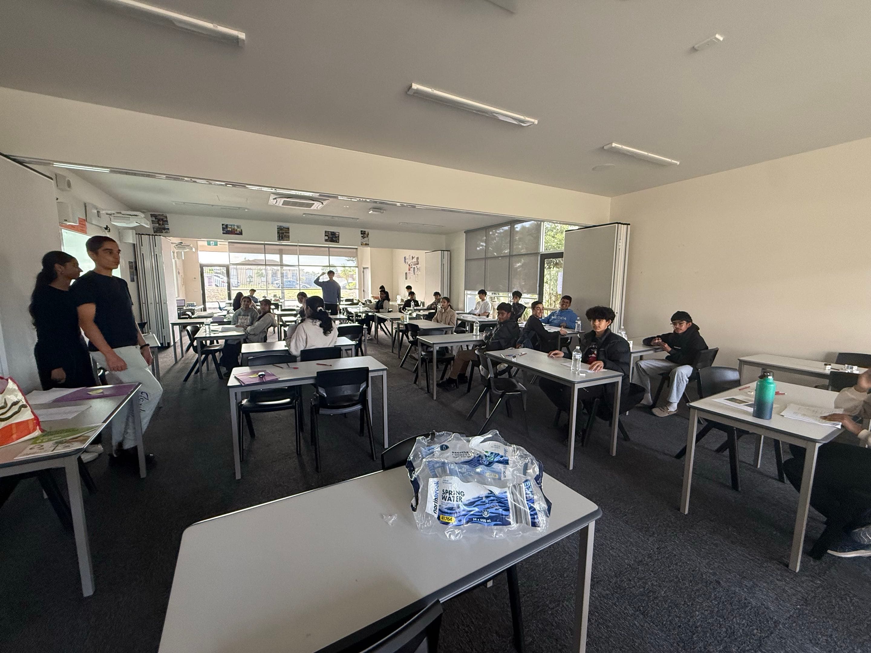 An in-person session in progress, the tutor standing at the front of a room of seated students.